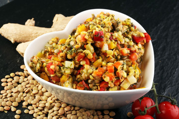 Lentil with carrot and pumpkin ragout in a wooden bowl on a wood