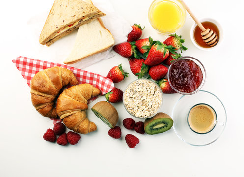 breakfast on table with sandwiches, croissants, coffe and juice