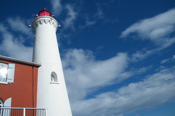White Lighthouse with Deep Blue Sky and White Clouds