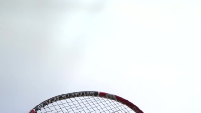 Slow motion badminton racket hitting a shuttlecock