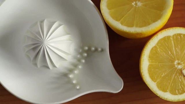 Lemon halfs and plastic juice squeezer for squeezing citrus sour drinks. Wooden table background top view. Dolly slider shot 4K ProRes HQ codec
