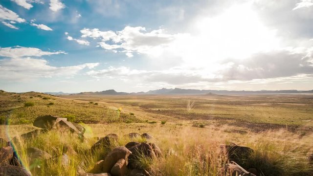 Holy grail linear timelapse showing the Karoo landscape and vistas stretched out down in the valley with a mountain in the distant background and rocks in the foreground.  Fast moving clouds blowing towards camera clearing up as it gets dark into the night with airglow in the sky available on request.