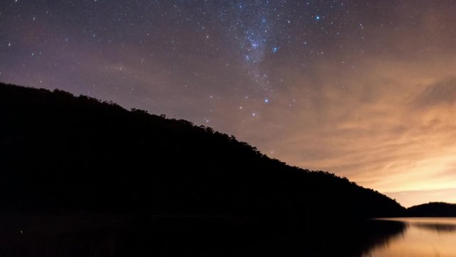 Linear and pan timelapse at night time of a silhouette mountain at a dam with the Milky Way and a dramatic thunderstorm with lightning flashes while a thunderstorm rolls in available on request.