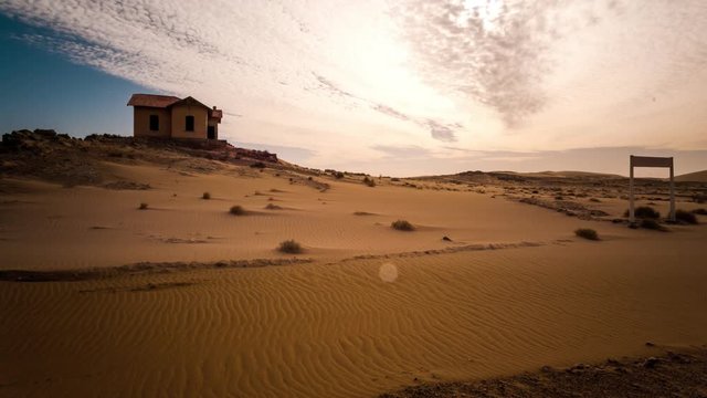 Static timelapse of an abandoned ghost town train station during a sandstorm while the sand is shifting in a landscape setting with dense scattered clouds in Southern Namibia close to LÌ_deritz, Kolmanskop.