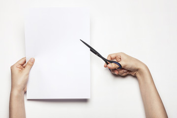 woman(female) hand hold a scissors with paper isolated white.