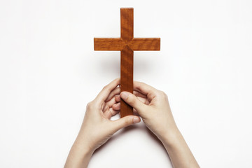 woman(female) hand hold a wood cross isolated white.