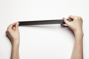 woman(female) hand hold a black tape isolated white.