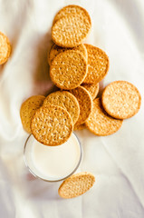 A glass of milk drink in a glass with a cookie