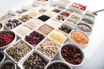 leguminous vegetables and spices in bowls, isolated on a white background