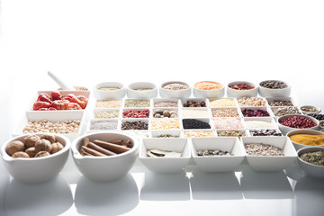 leguminous vegetables and spices in bowls, isolated on a white background