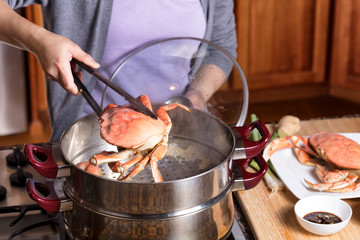 Hand removing cooked crab from steam pot © tab62