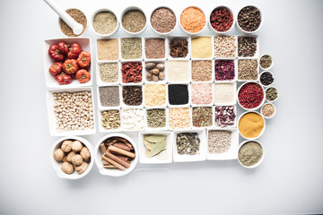 leguminous vegetables and spices in bowls, isolated on a white background