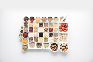 leguminous vegetables and spices in bowls, isolated on a white background