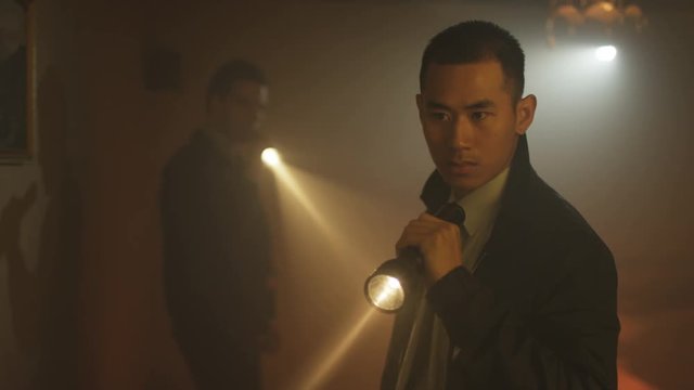  Portrait of tough guy cop investigating crime scene with his partner