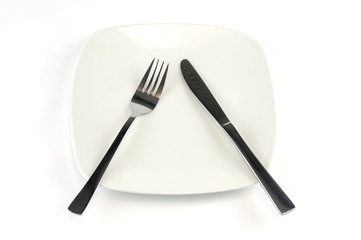 fork and knife in white plate isolated on background