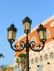 Fototapeta na wymiar Vintage Old Fashioned Street Light against mansion in blue sky