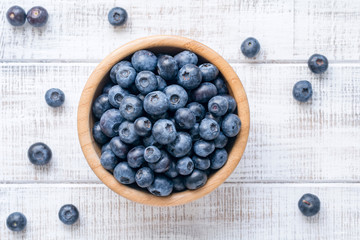 Bowl of fresh blueberries on vintage white background. Top view - 144495742