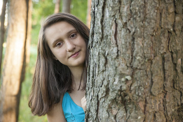 Portrait of a girl behind a tree 