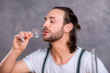 young man drinking clear spirit