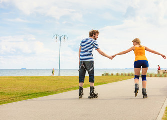 Young couple on roller skates riding outdoors