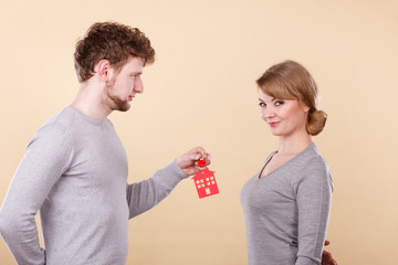 Couple holding key with house symbol