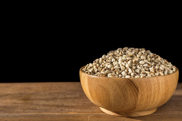 Close up millet rice or millet grains in bowl on wooden table. Isolated on black