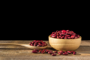 Red bean in bowl on wooden table. Isolated on black background