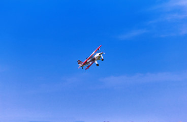 Flight of a sport aircraft against a blue sky.