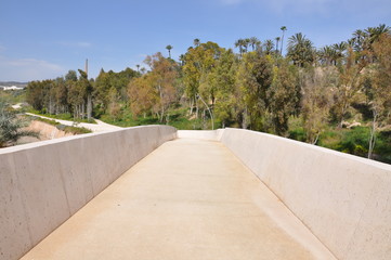 Bridge of wood and concrete leading to the sea and the park