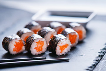 Sushi rolls with salmon, soy sauce and chopsticks 