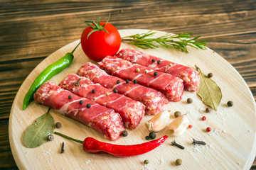 Raw cevapcici dish of mixed meats, the food of the Balkans. Minced meat and bacon.