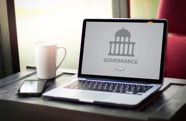 Fototapeta premium GOVERNANCE and building, Authority Computing Computer Laptop with screen on table Silhouette and filter sun