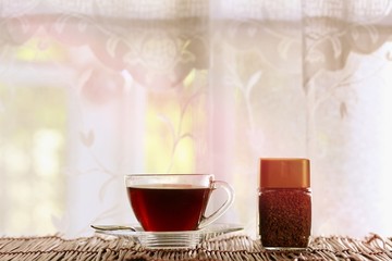 Coffee cup and coffee bottle on table near window blur background
