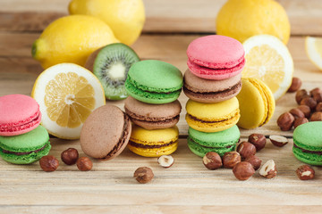 Green, pink, yellow and brown french macarons with lemon, kiwi and hazelnuts