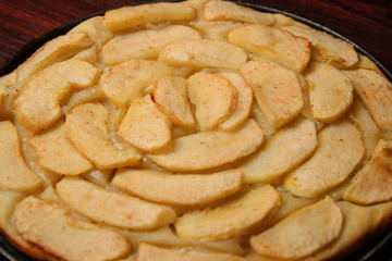 Close up photograph of a freshly made apple pie with apple slices