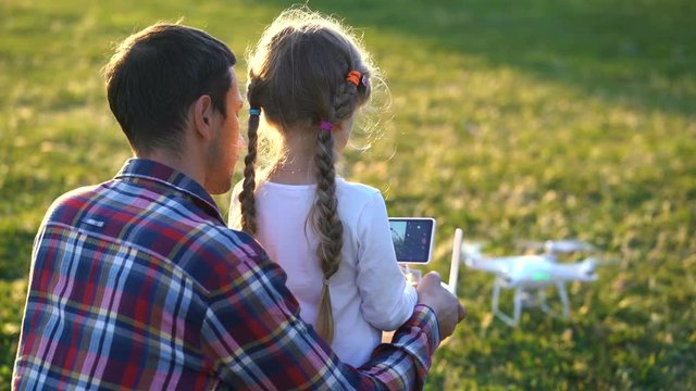 father shows his daughter how to control drone