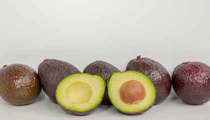 Brown avocado isolated with green half with seed white background