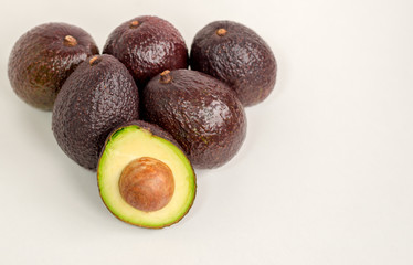 Brown avocado isolated with green half with seed white background