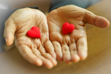 Female hands giving two red hearts