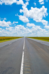 Long road ahead under a blue sky