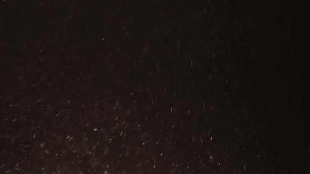 Slow motion of orange dust particles with ligh tleak fly in the air, 180fps prores footage