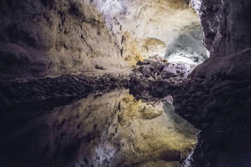 Fototapeta na wymiar Quiet water reflection on a rock cave