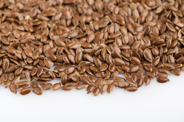 close up of flax seeds isolated on white background. Bowl full of brown flaxseed or linseed. Cereals. Vitamins. Healthy food.