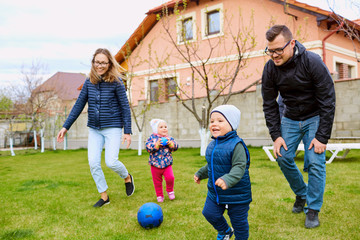Parents, mother, father and son play in the yard of house on  grass.