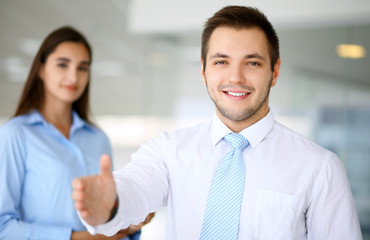 Smiling businessman  in office with colleagues in the background