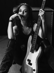 Beautiful bass player sitting with her guitar