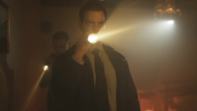  Portrait of tough guy cop investigating crime scene with his partner