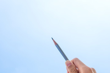 hand holding pencil for writing on blue sky background