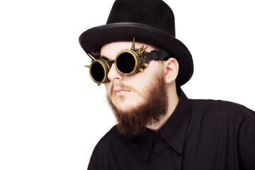 Handsome young man with long beard and moustache on face in steampunk glasseses on white background