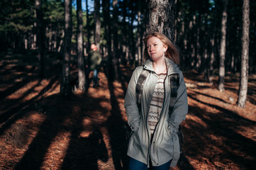 A loving guy with a girl is walking through the woods in the rain.